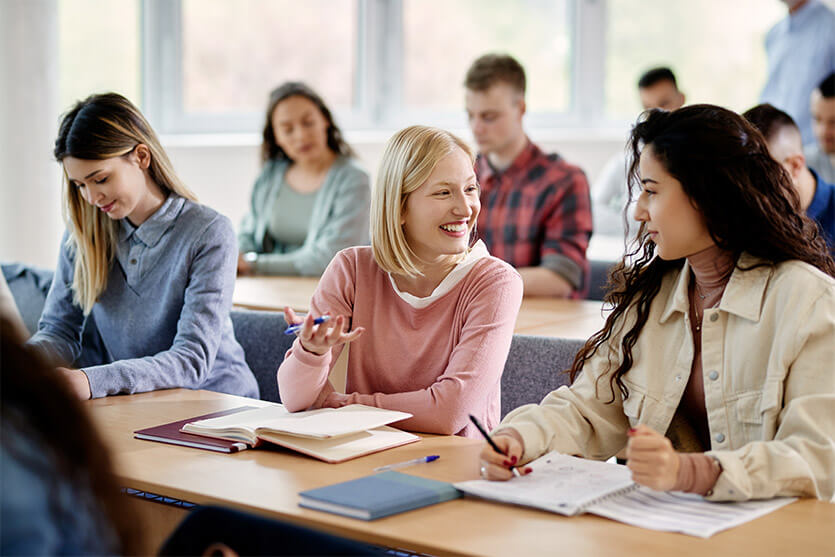 a classroom setting with two girls talking