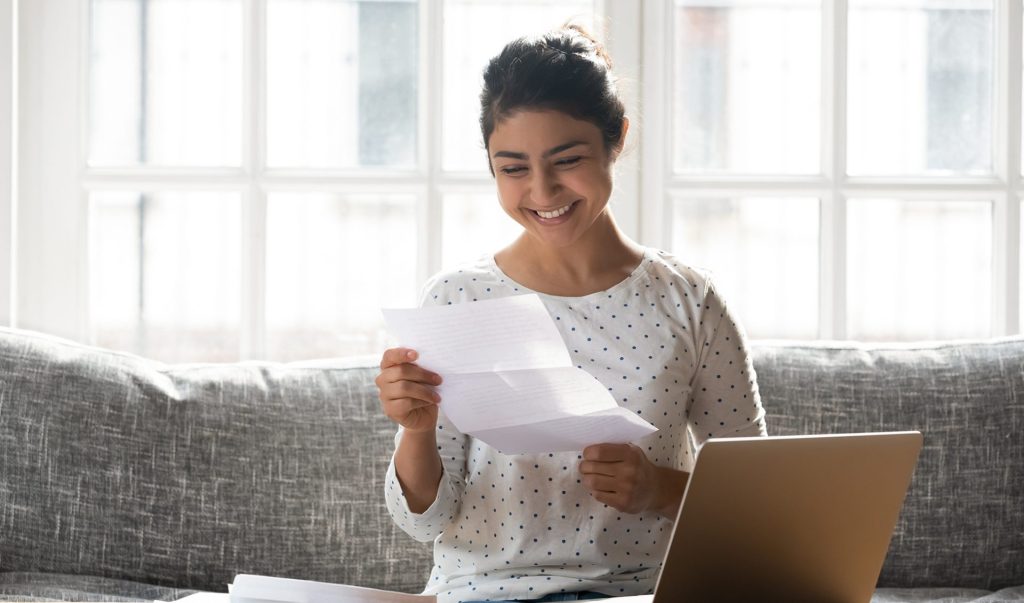 women smiling at a piece of paper